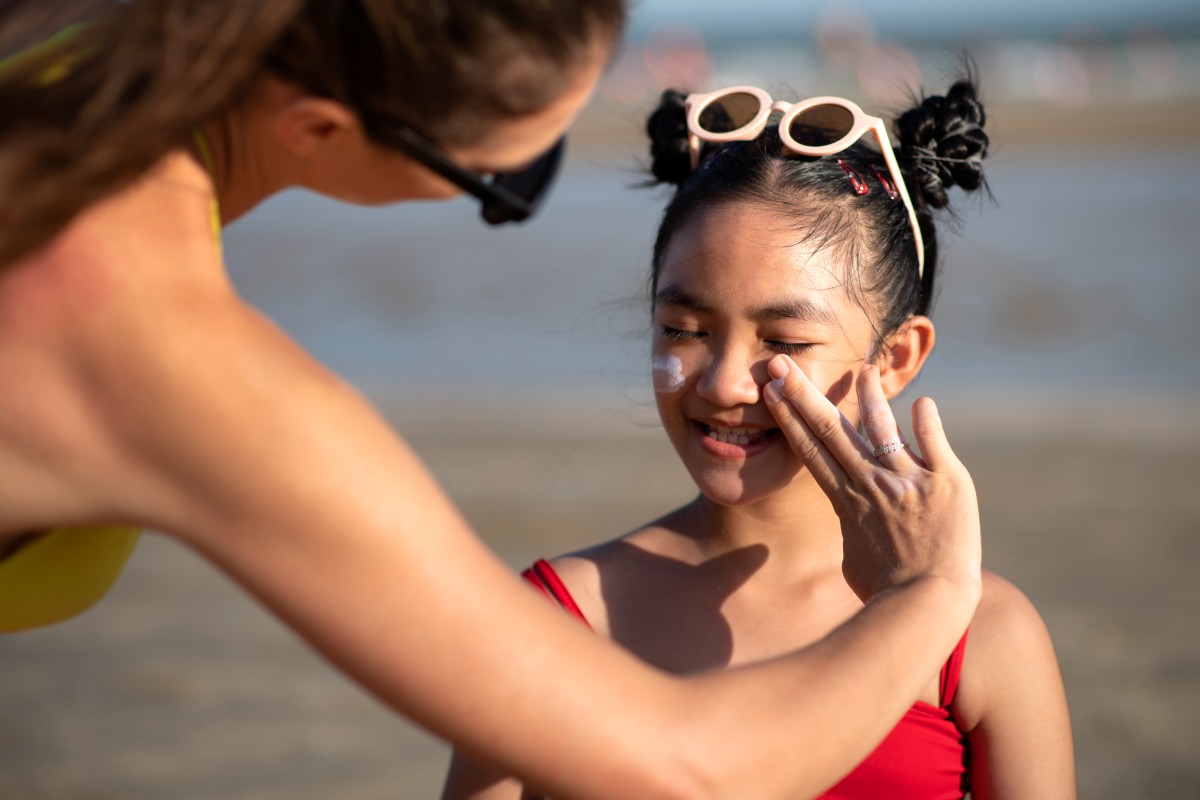 woman-applying-sunscreen-kid-front-view